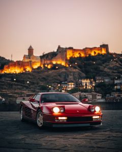a red sports car parked in front of a castle